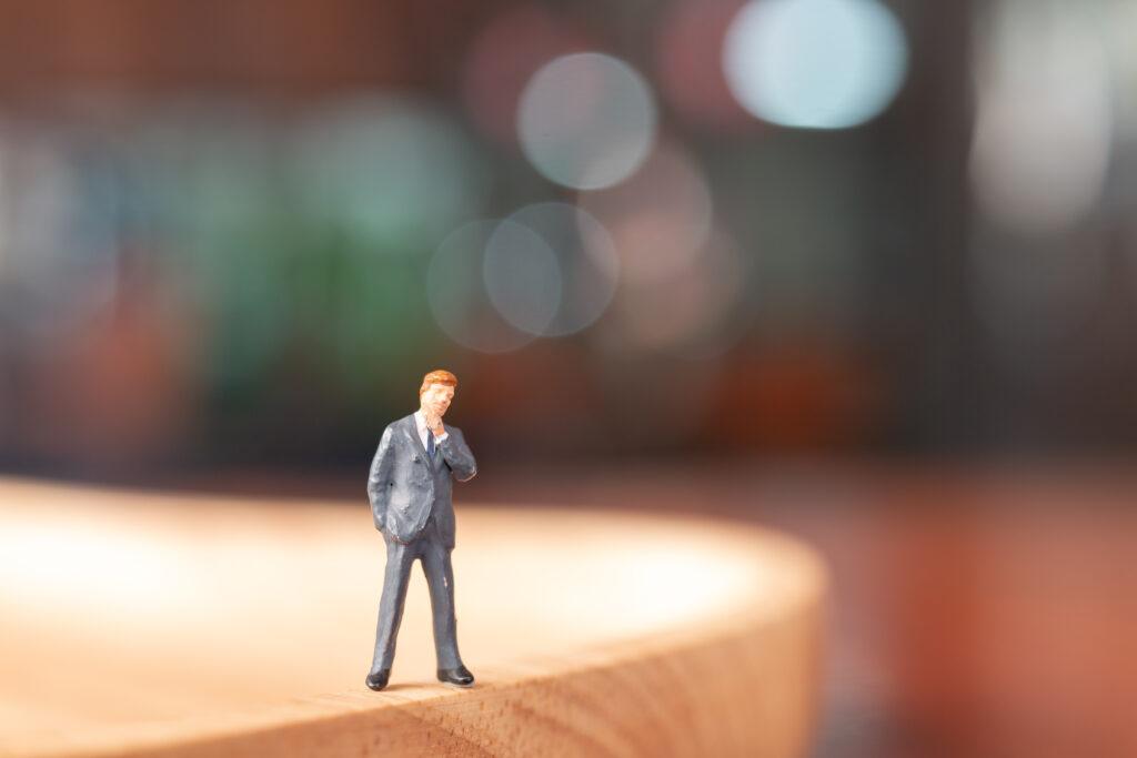 Miniature people : Businessman standing and thinking with colorfull background
